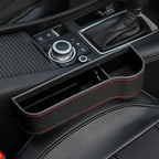 Car interior with a black leather gear shift cover featuring red stitching.